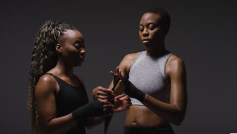 Studio-Shot-Of-Women-Putting-On-Boxing-Wraps-On-Hands-Before-Exercising-Together-7